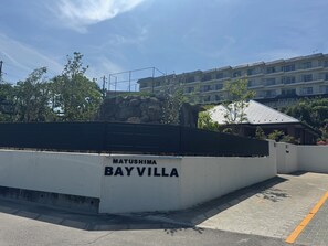 A parking area with a white wall labeled "MATUSHIMA BAYVILLA".