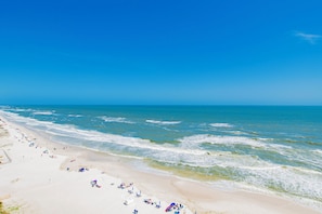 A beach with wide sandy shores and gentle waves.