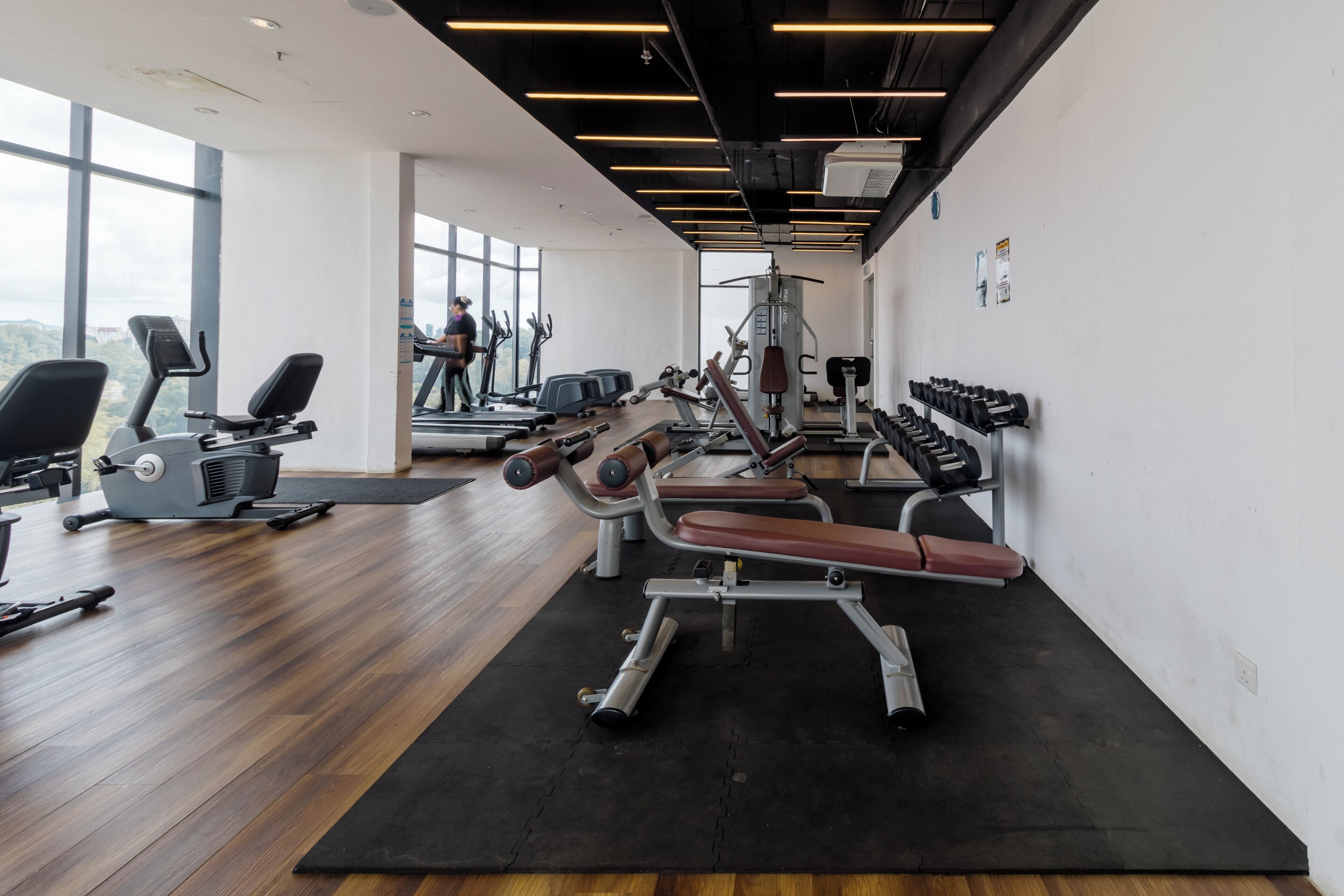 A gym with cardio machines, weight benches, and free weights.