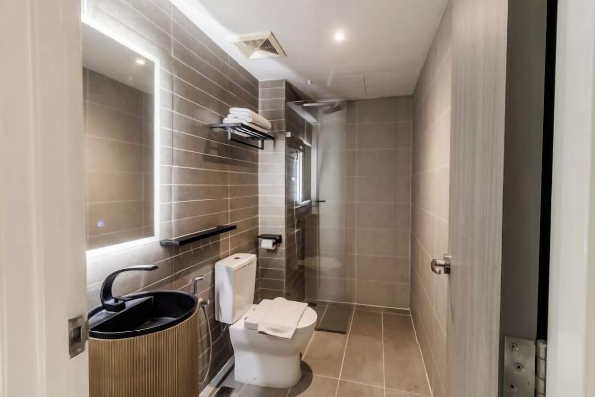 A modern bathroom with a toilet, sink, and shower.