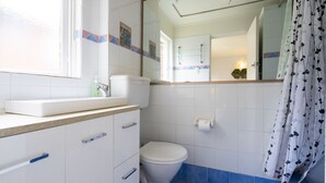 Un baño con inodoro, lavabo y espejo.