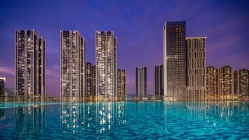 Una piscina al aire libre, sillones reclinables de piscina