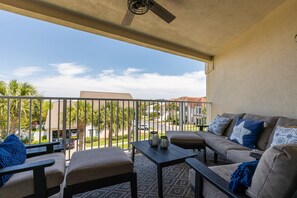 Relax on the balcony with a sofa, armchairs, and a small table, taking in the views of the surrounding neighborhood.
