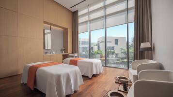 Relax in a stylish room with two beds, a seating area, and a large window offering views of the surrounding cityscape.