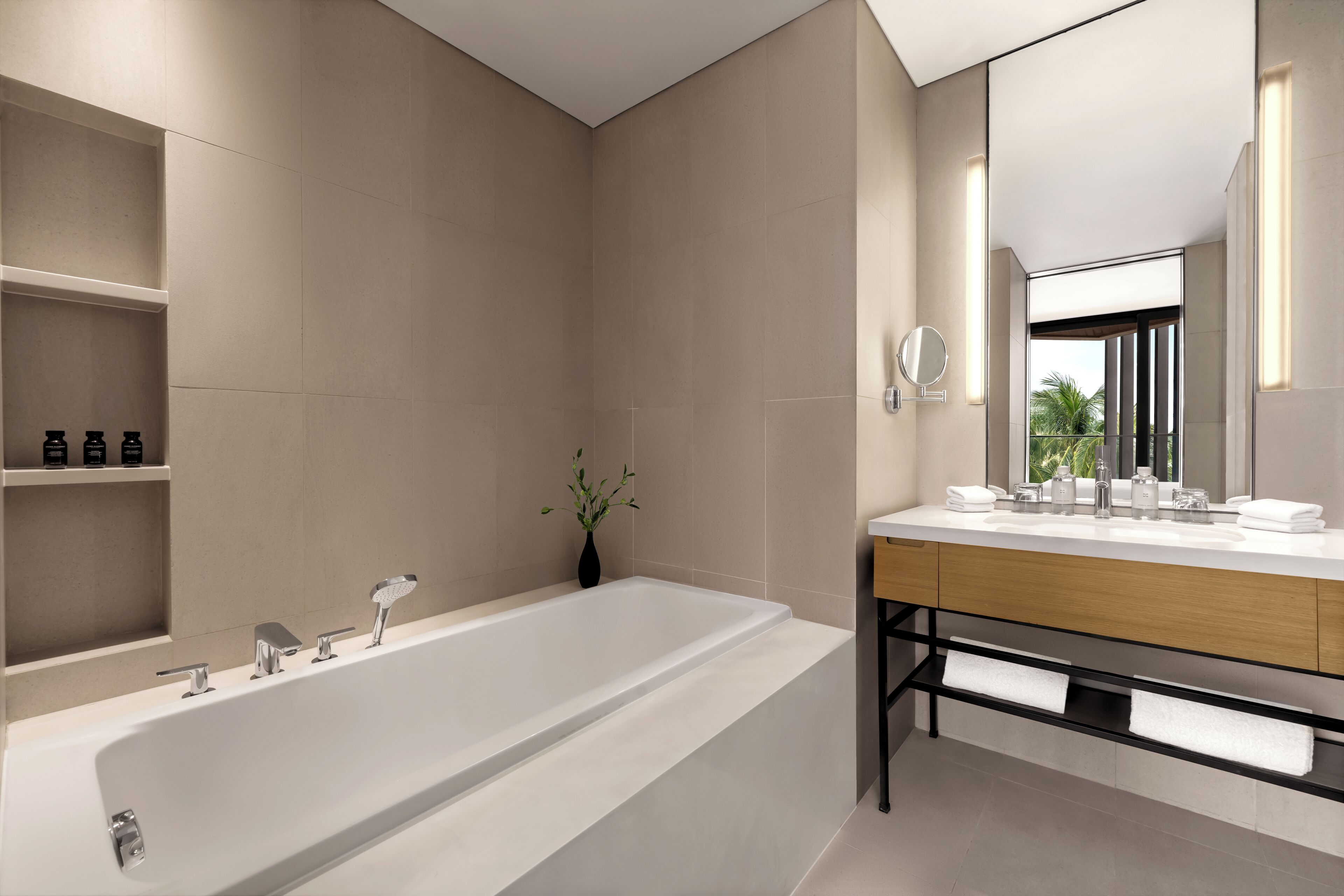Une salle de bain moderne avec une grande baignoire, un meuble-lavabo en bois et un miroir.