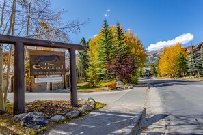 A wooden signboard for The Corral South Range with a horse silhouette, indicating a lodging area. - Top-Floor Ski Condo, Hot Tub & Mountain Views, Walk to Lifts (Breckenridge)