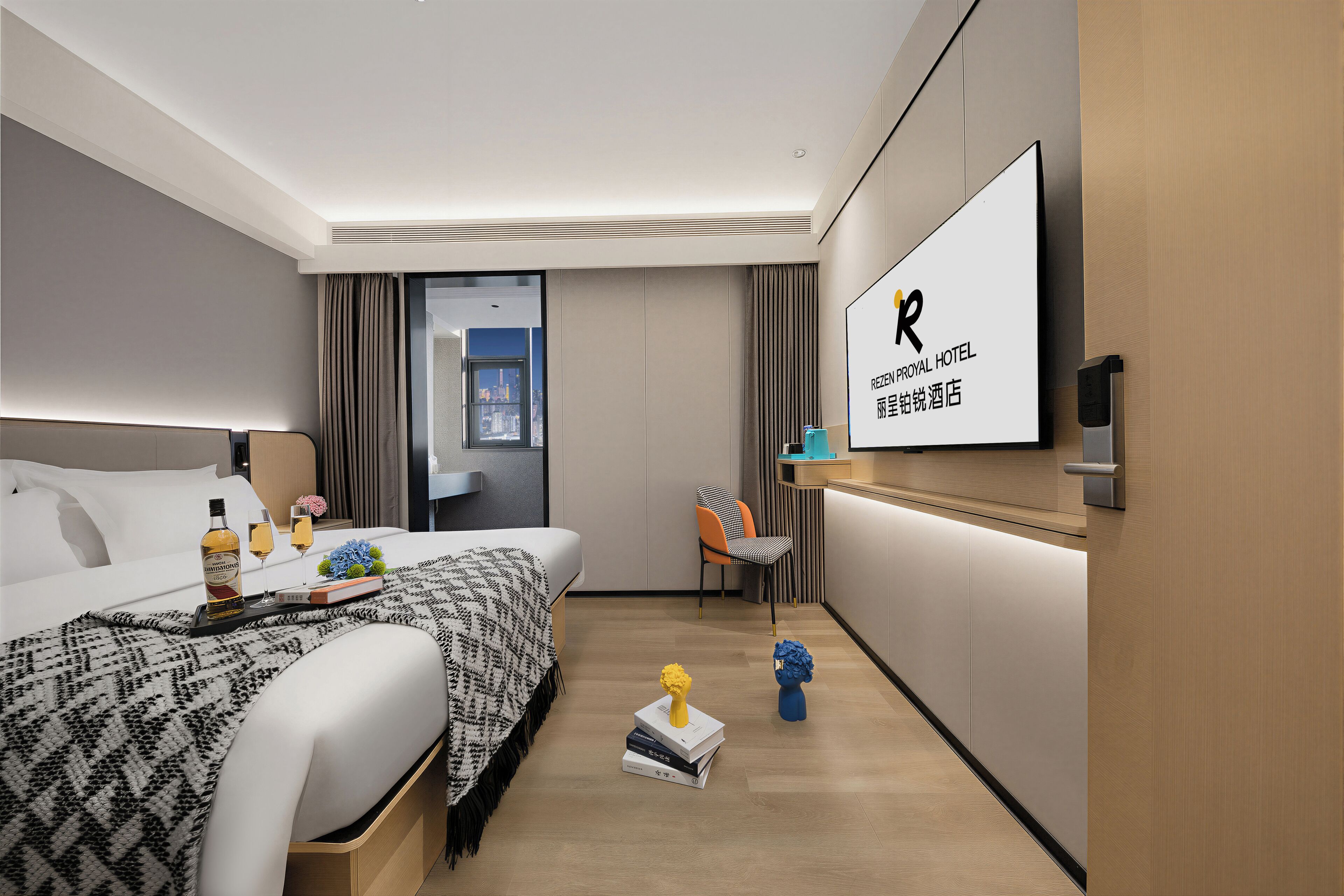 Habitación de hotel con cama, mesita de noche, televisor y vistas a la ciudad.