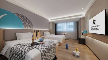 Habitación de hotel con dos camas, televisor, escritorio y un ventanal grande.