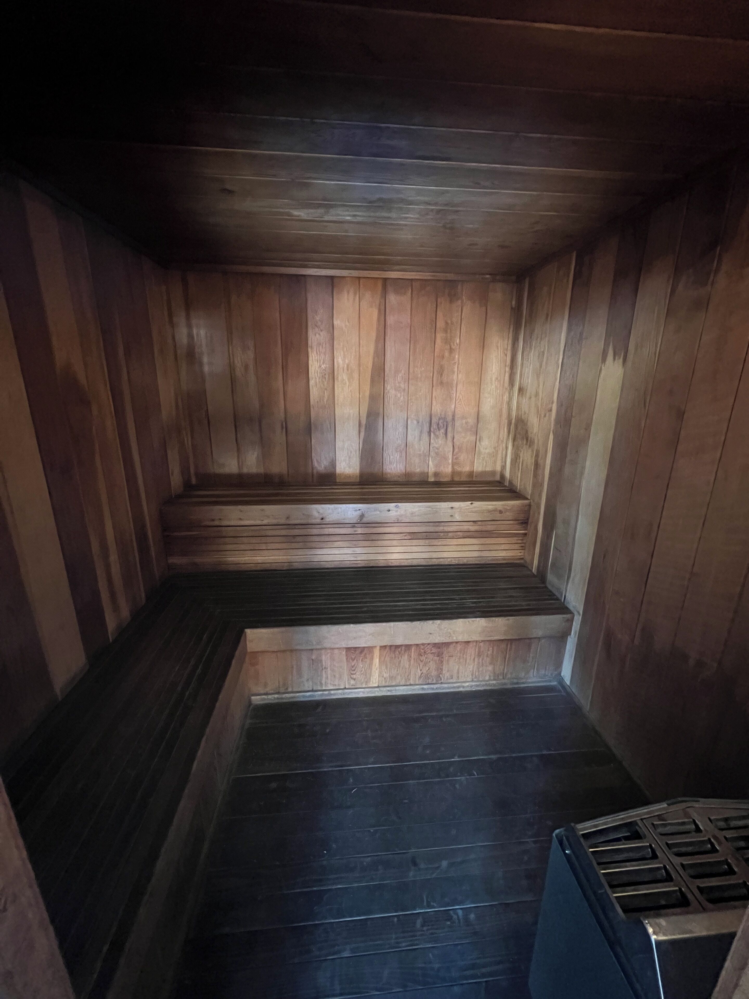 Een houten sauna met een trap naar een bank.