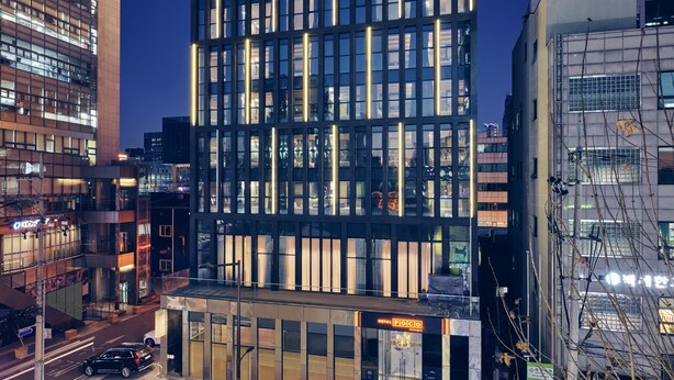 Un moderno edificio di un albergo con una segnaletica ben visibile che riporta la scritta 'HOTEL POCO'.
