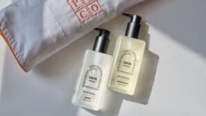 Un asciugamano bianco con 'POCO' ricamato in rosso, due flaconi di shampoo 'KOLON HOTEL' e un flacone dosatore di bagnoshampoo corpo 'SW19 Still Moon'.