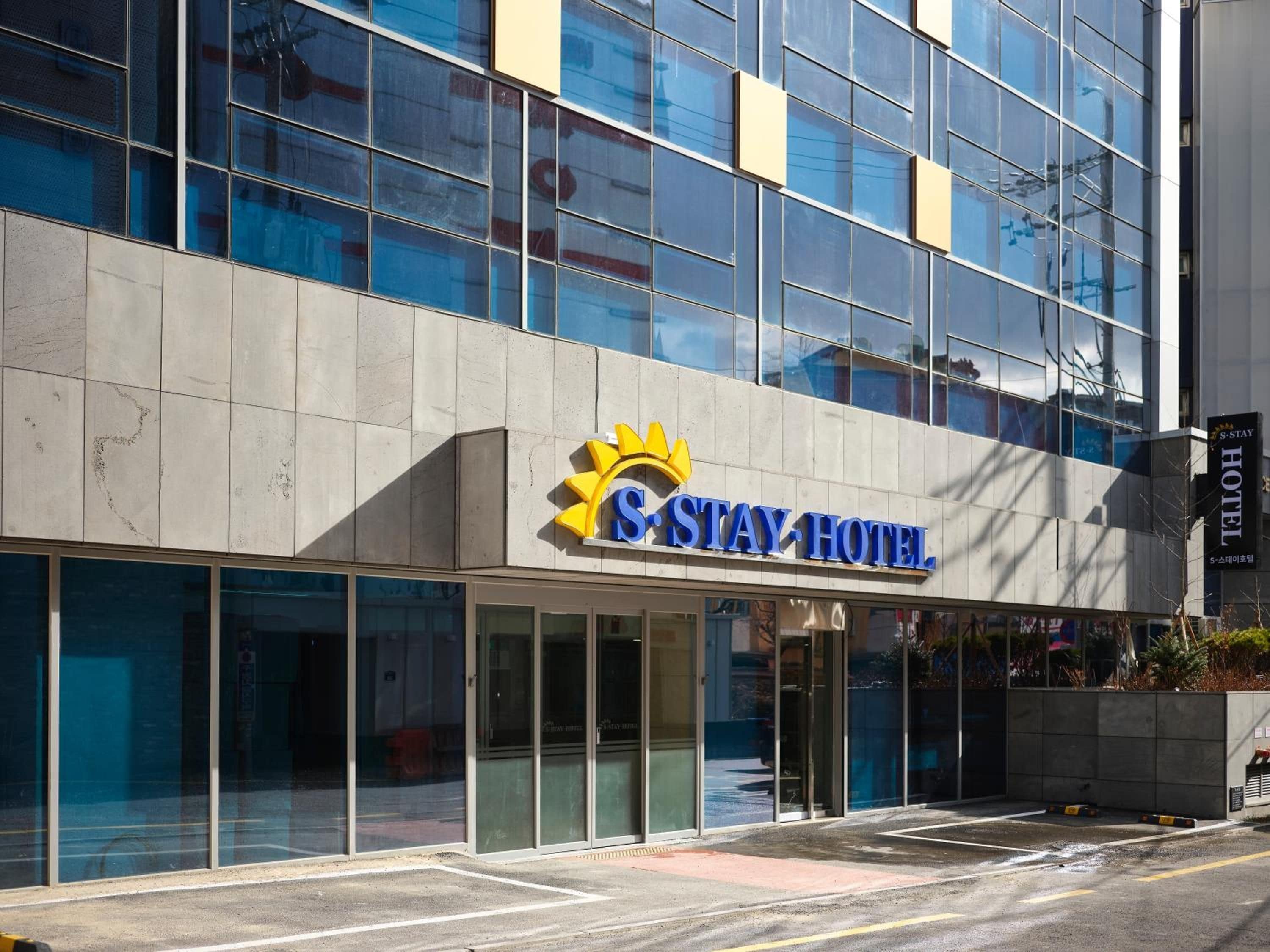 Un hotel moderno con fachada de vidrio y un logotipo destacado.