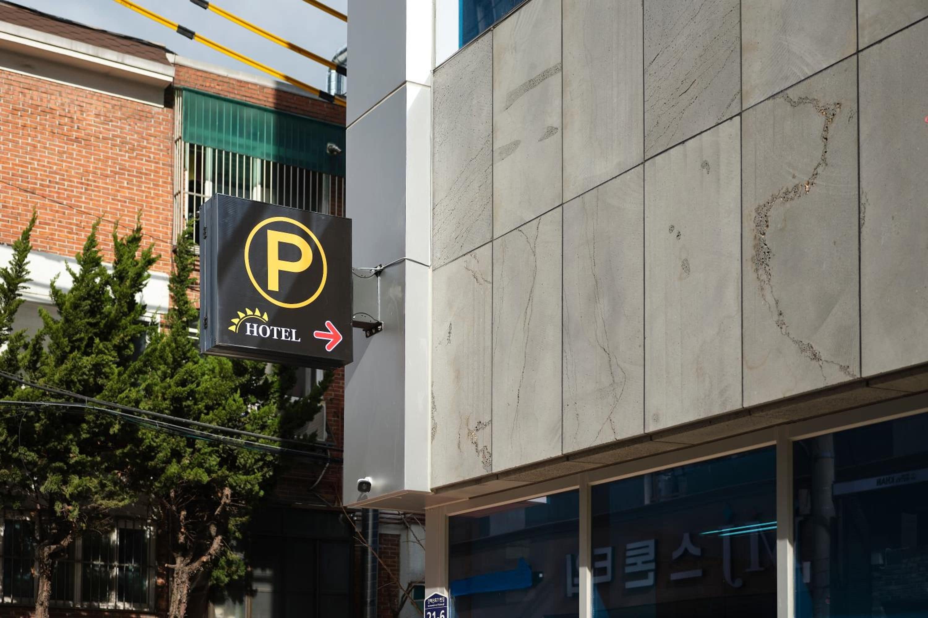 A hotel sign with a parking symbol and an arrow indicating direction.
