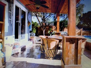 Un espace extérieur aménagé en terrasse, avec des meubles en osier et des plantes en pot.