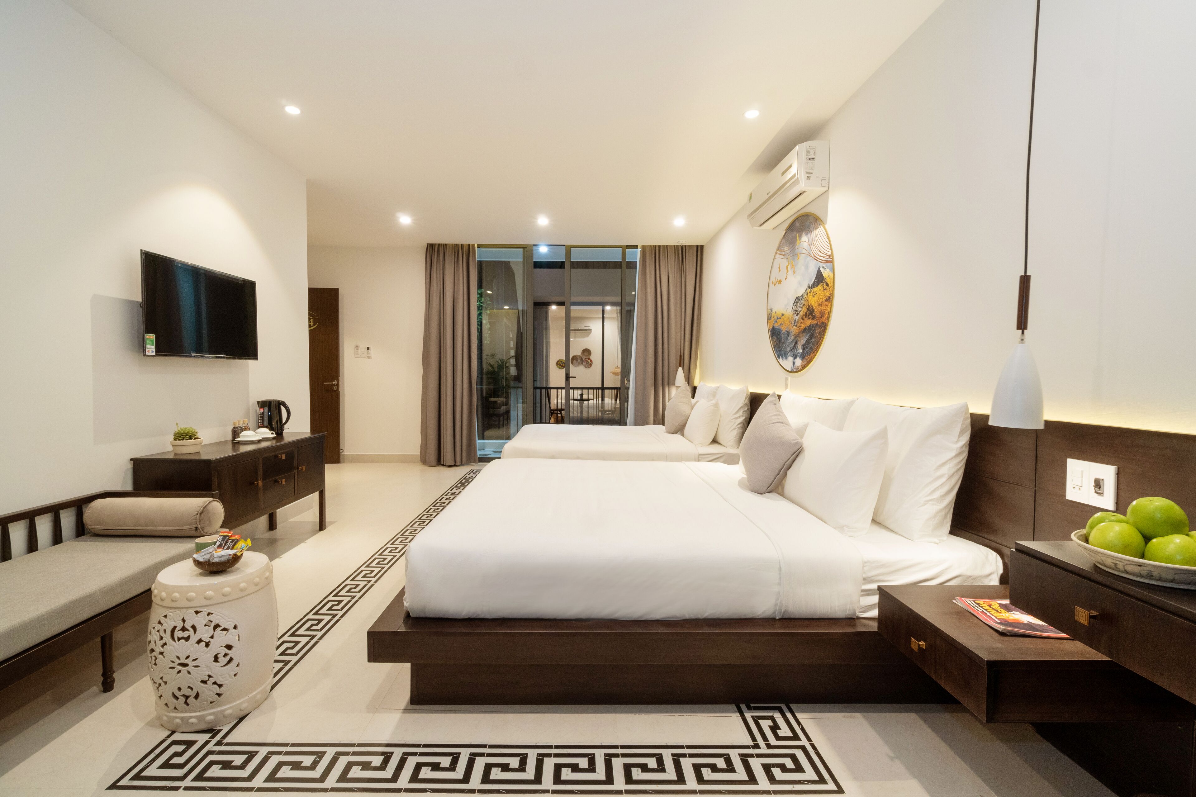 Una habitación de hotel moderna con una cama grande, un televisor, un escritorio y vistas al exterior.