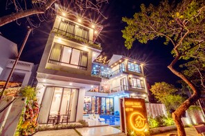 Vista frontal de la propiedad por la tarde o noche