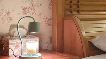 A wooden bedside table with a lamp, a tissue box, and a glass of water.