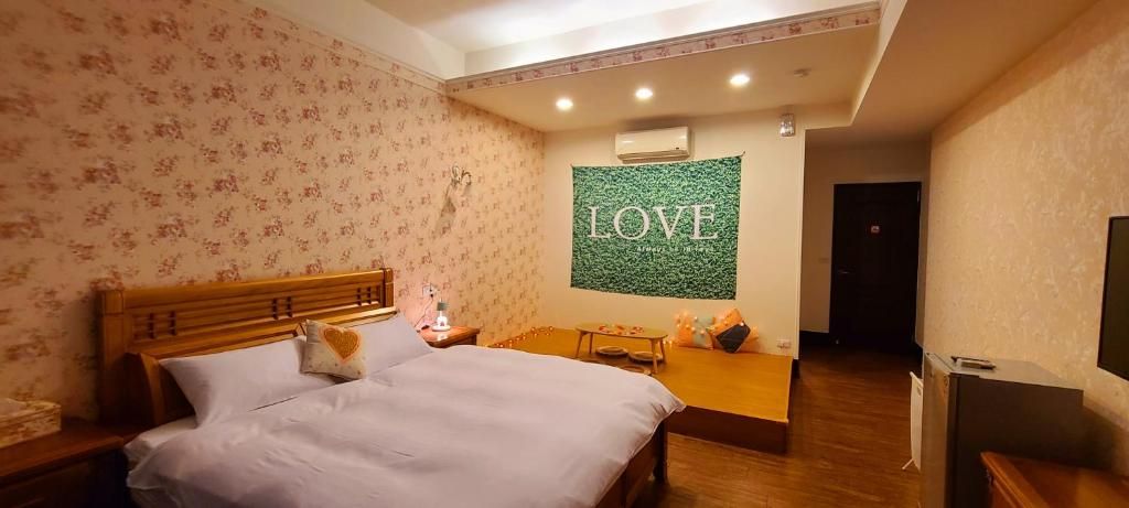 A hotel room with a bed, a small table, a sofa, and a TV.