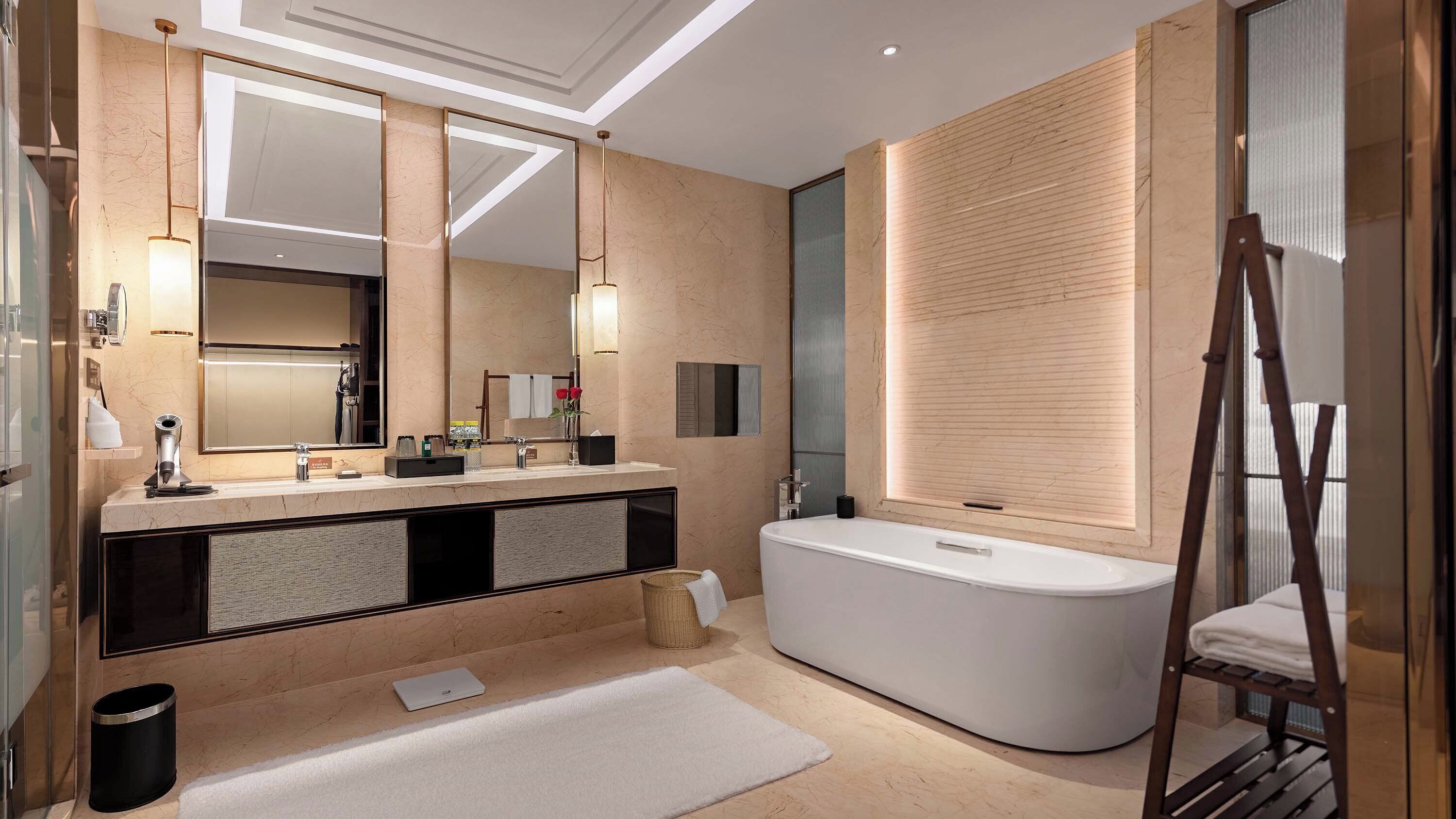 A modern bathroom with a large mirror, a freestanding bathtub, and a wooden panel wall.