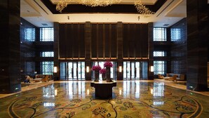 A spacious lobby with a polished floor, a central floral arrangement, and large windows allowing natural light. - Haikou Yatter Hotel, Vignette Collection by IHG (Haikou)
