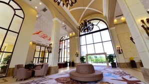 A spacious lobby with high ceilings, large windows, and a central seating area. - Yinghai Hotel Apartment Zhuhai Chimelong (Zhuhai)