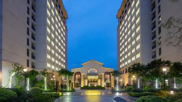 A hotel entrance with a central archway, flanked by two tall buildings, and a well-lit pathway leading to the entrance. - Yinghai Hotel Apartment Zhuhai Chimelong (Zhuhai)