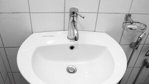 A white bathroom sink with a single faucet and a handheld showerhead. - Sana's Beach Guesthouse and Restaurant (Negombo)