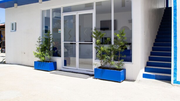 A building with a blue roof, large glass doors, and a staircase with blue steps. - Skytel Palawan (Puerto Princesa)