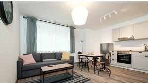 Un appartement moderne comprenant un salon, un coin repas et une cuisine.
