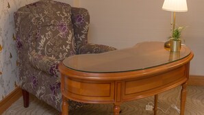 Une pièce d’angle avec un bureau en bois, une chaise et une lampe.