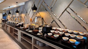 Un aparador tipus buffet amb diverses estacions de servei, un disseny de paret modern i il·luminació penjant.