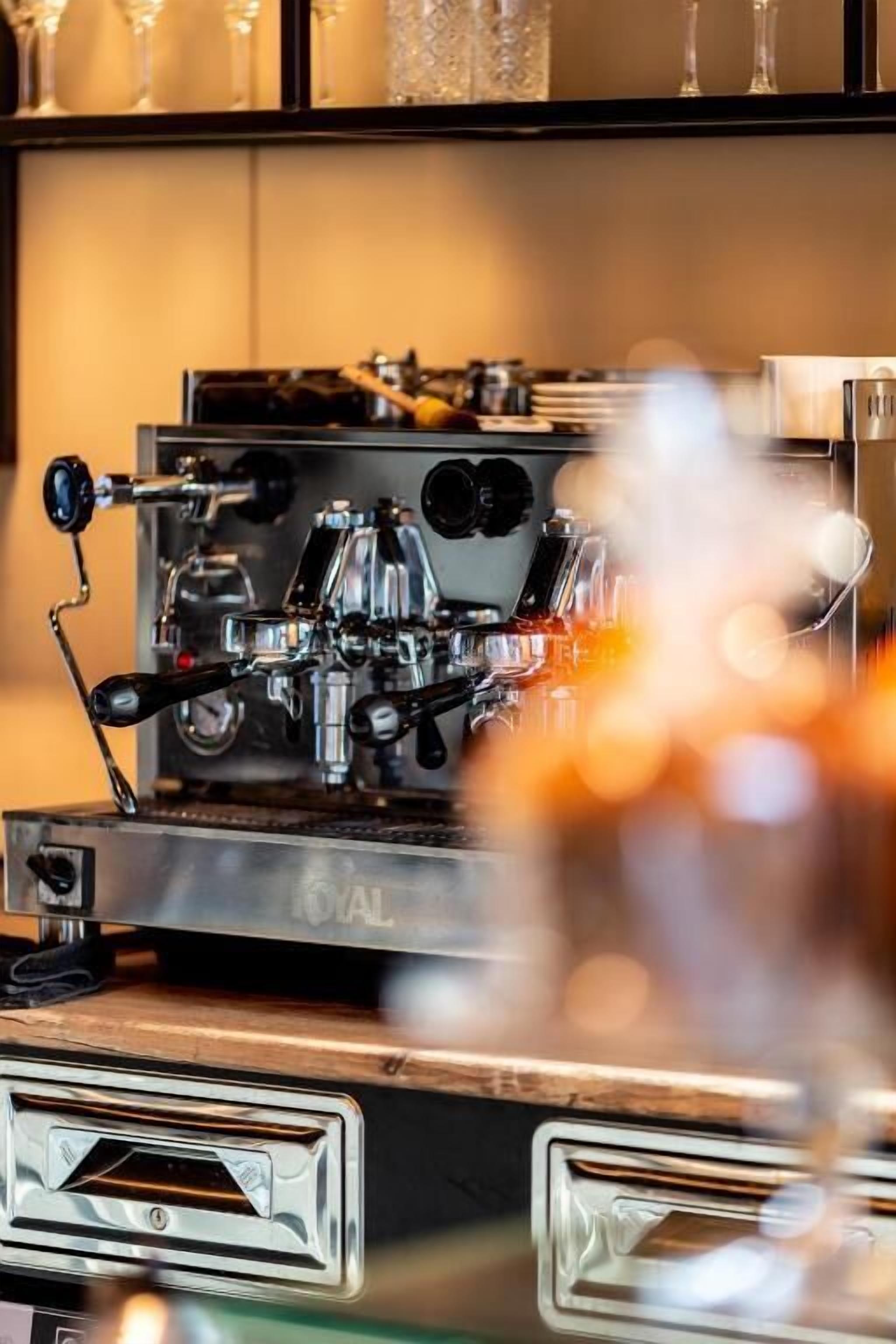 Una cafetera con un panel de control y depósito de agua.