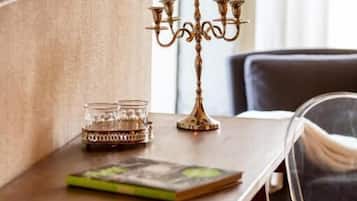 A wooden table with a brass candelabra, a glass candle holder, and a book.