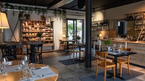 A restaurant with multiple dining tables, chairs, and a bar area. - Hotel de l'Ours Preles (Plateau de Diesse)