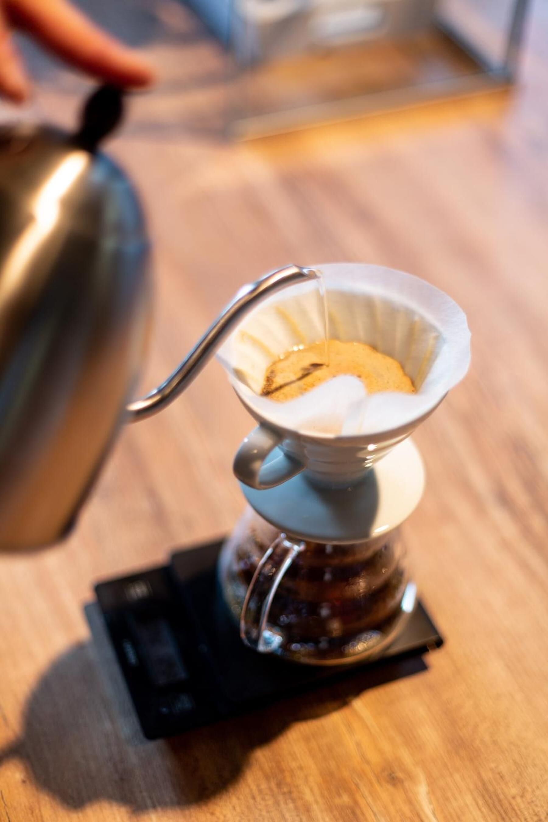 Une machine à café avec un filtre en papier, posée sur une table en bois.