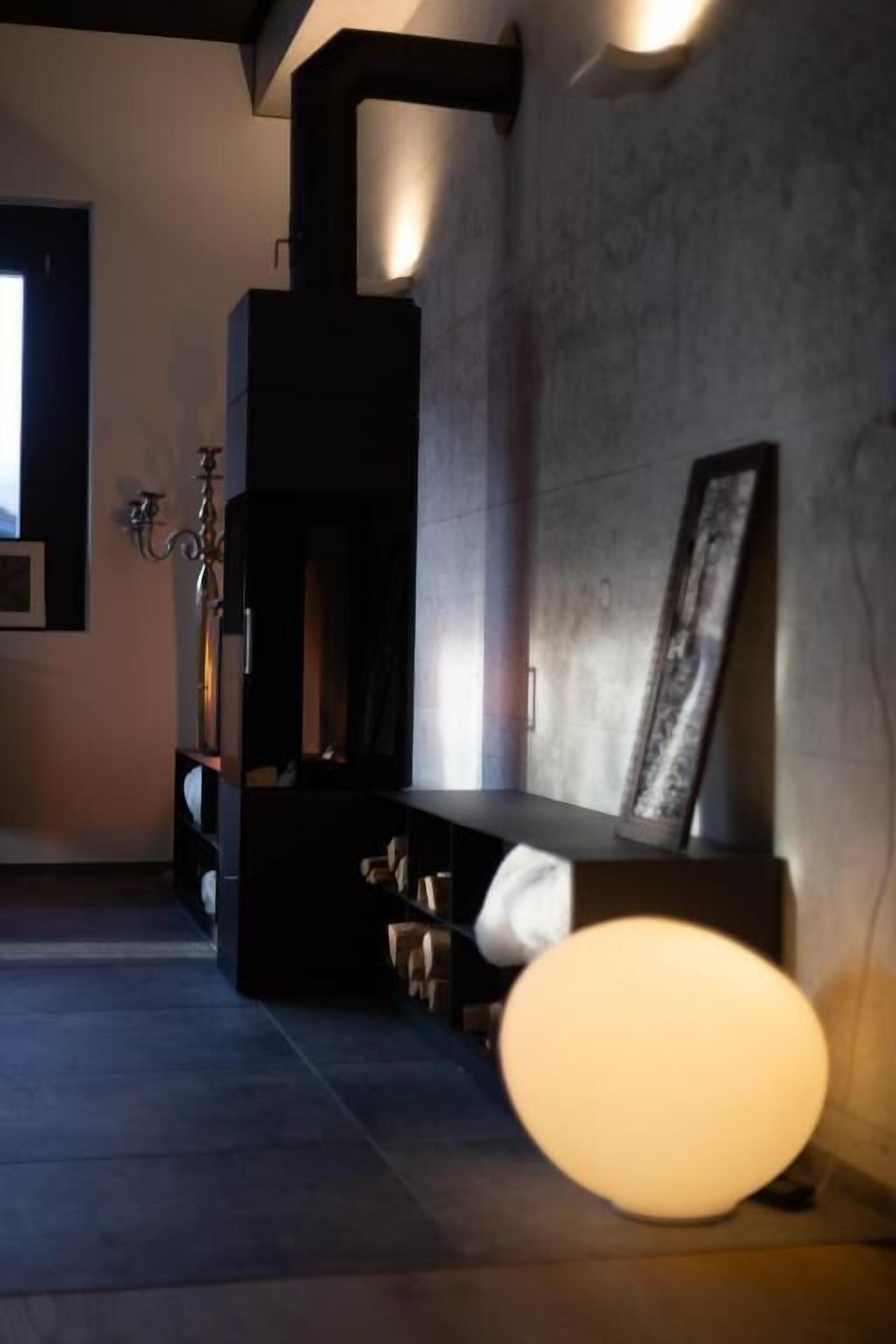 A modern interior with a fireplace, a bench, and a wall-mounted light fixture.