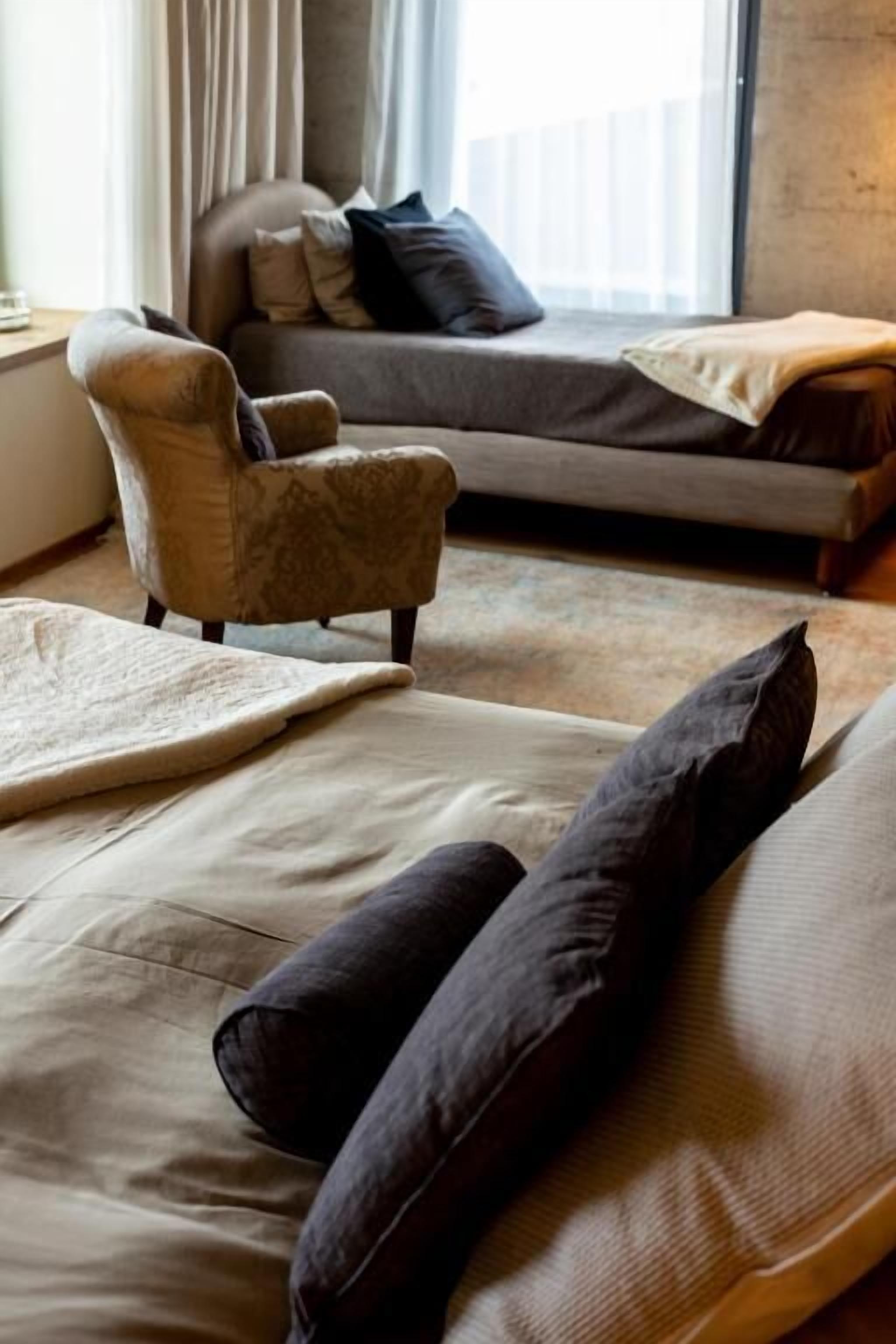 Un salon moderne avec un canapé, un fauteuil et une grande fenêtre.