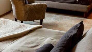 Un salon moderne avec un canapé, un fauteuil et une grande fenêtre.