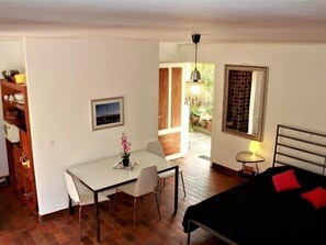 Ein Schlafzimmer mit Bett, Nachttisch, Stuhl, Schreibtisch und Fenster.