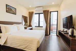 Une chambre d’hôtel avec un grand lit, un téléviseur à écran plat, une machine à café et une vue sur l’extérieur.