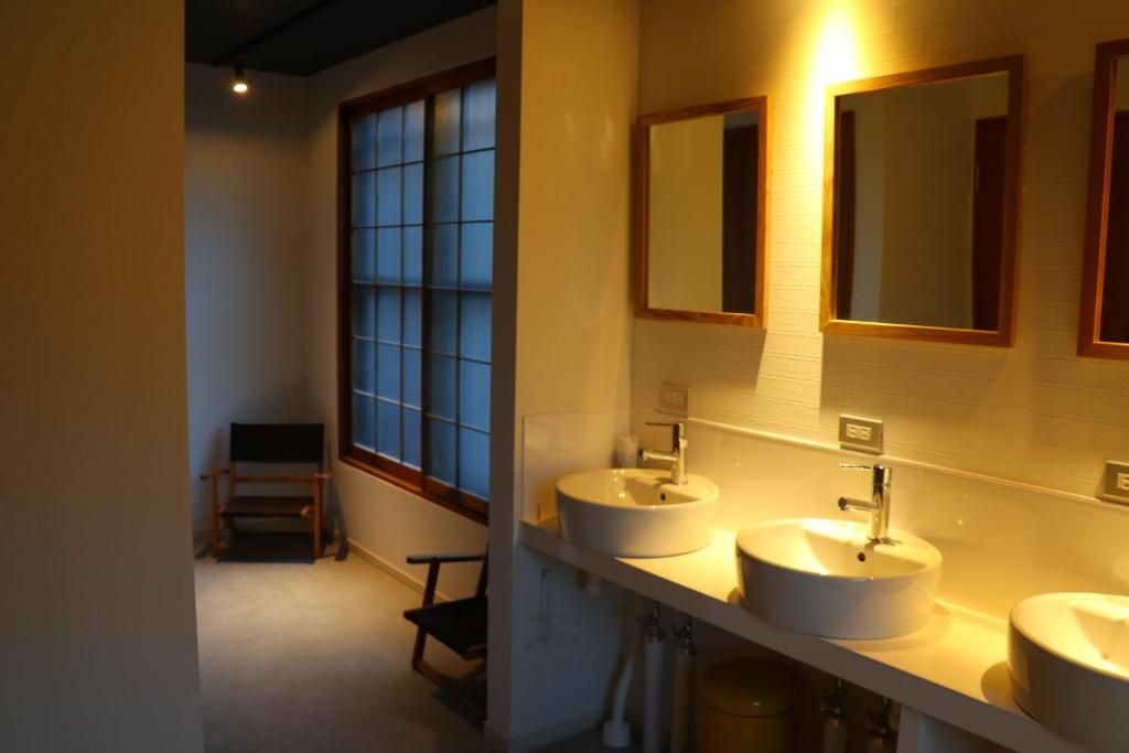 A bathroom with two sinks, a mirror, and a window.