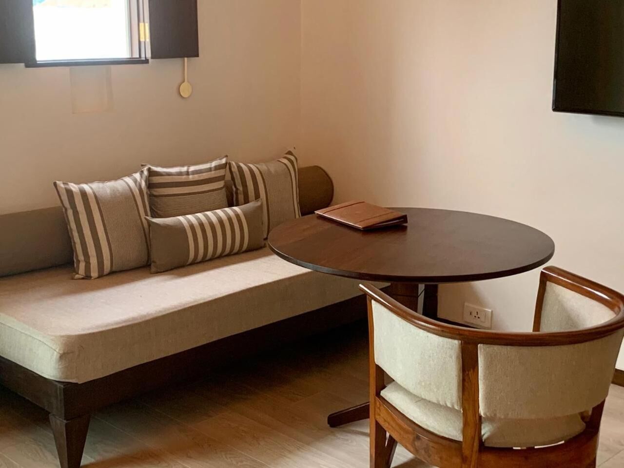 A living room with a sofa, a round table, and a chair.