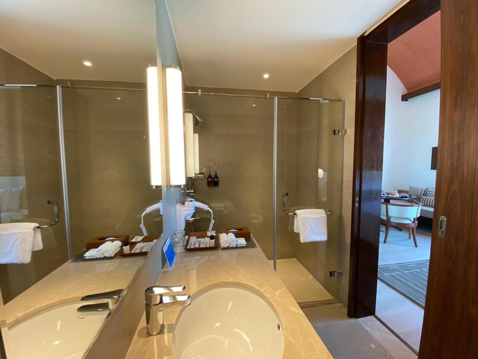Un baño moderno con un espejo grande, una bañera y zona de ducha.