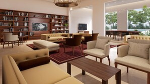 Una sala de estar moderna con sofás, una mesa de centro y una estantería llena de libros.