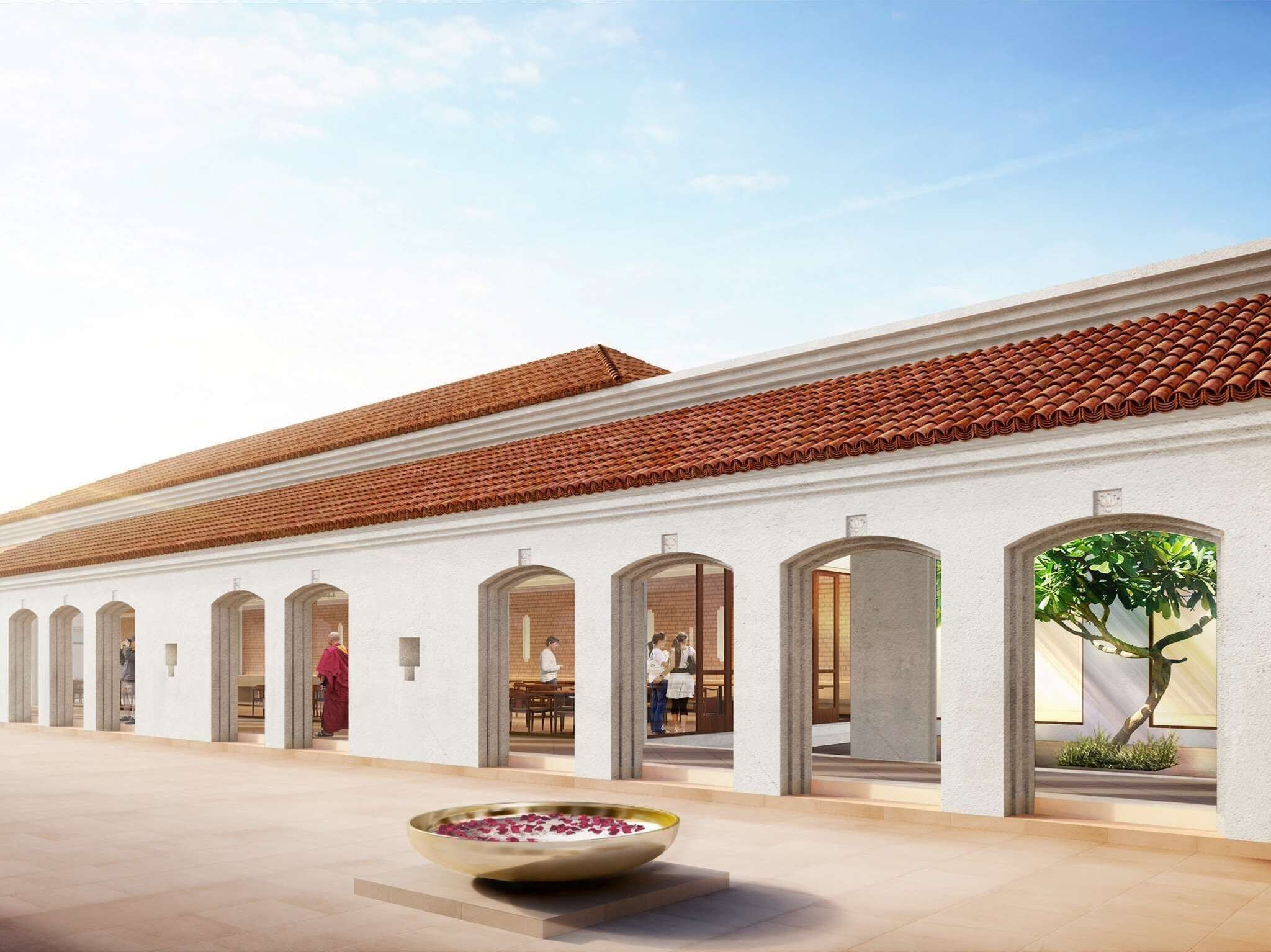 Un bâtiment doté d’un toit en tuiles, de portes en arc de cercle et d’une cour intérieure agrémentée d’un arrangement floral.