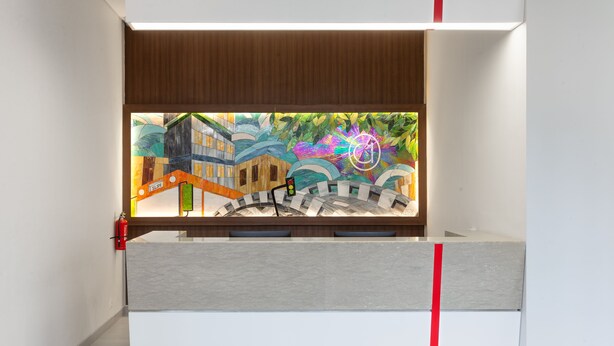 A modern interior with a view of a colorful mural, a wooden ceiling, and a red stripe on the wall.