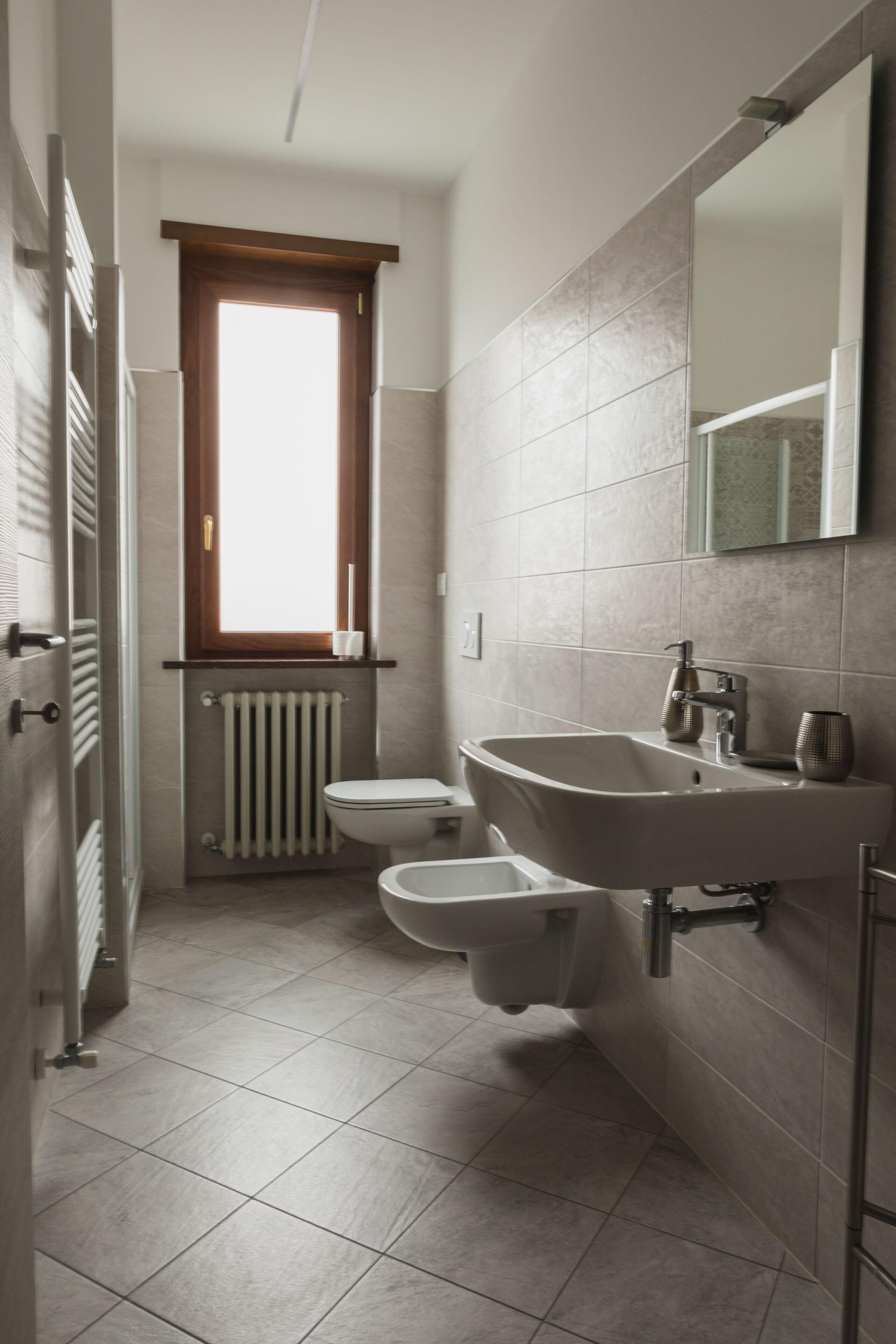 A compact bathroom with a toilet, bidet, and sink.