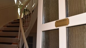 Een trap met een witte leuning en een bordje met de tekst Villa Hünichen Withen.