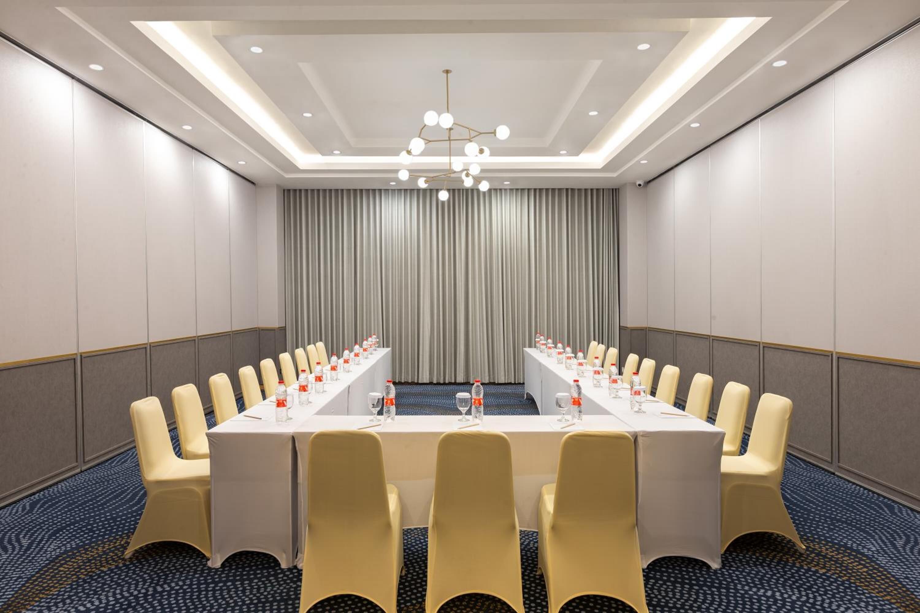 A conference room with a long table, chairs, and a chandelier.