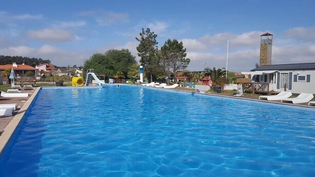 A swimming pool with a slide and a lifeguard tower. - Quinta do Valão (Alcobaça)